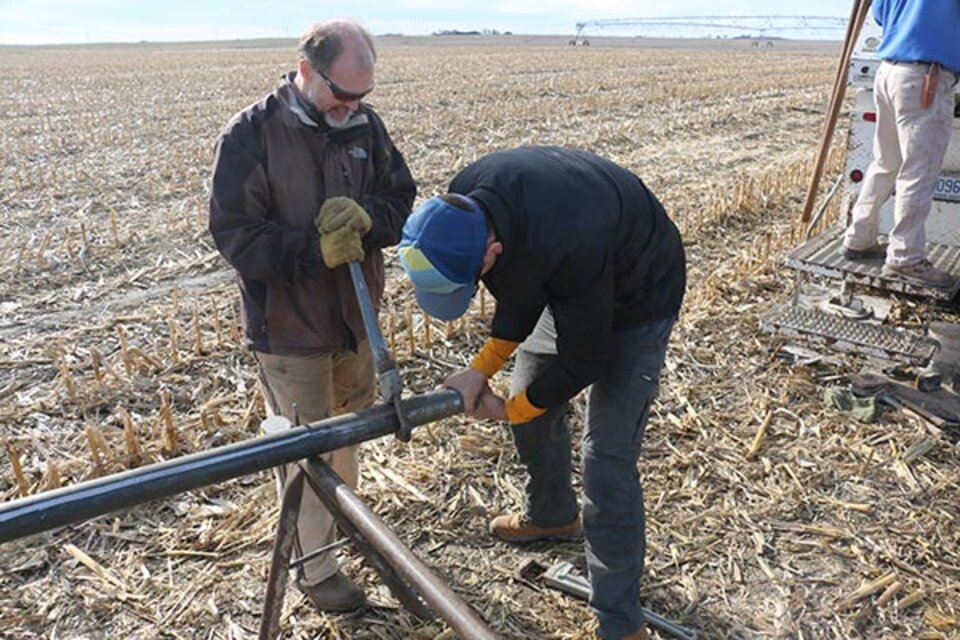 Two people working on end of pipe