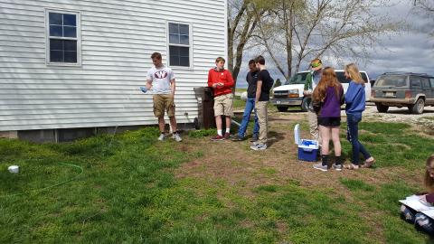 students testing water in backyard